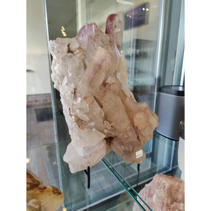 Lithium quartz cluster weighing 7.55kg featuring translucent pink and clear quartz cluster with jagged faceted edges on stand