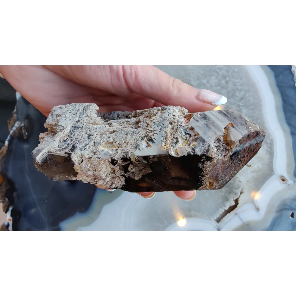 Hand holding lodalite included smoky quartz crystal from Brazil