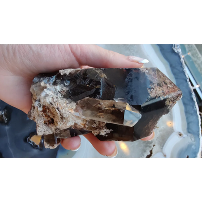 Hand holding lodalite included smoky quartz with phantom crystals from Brazil