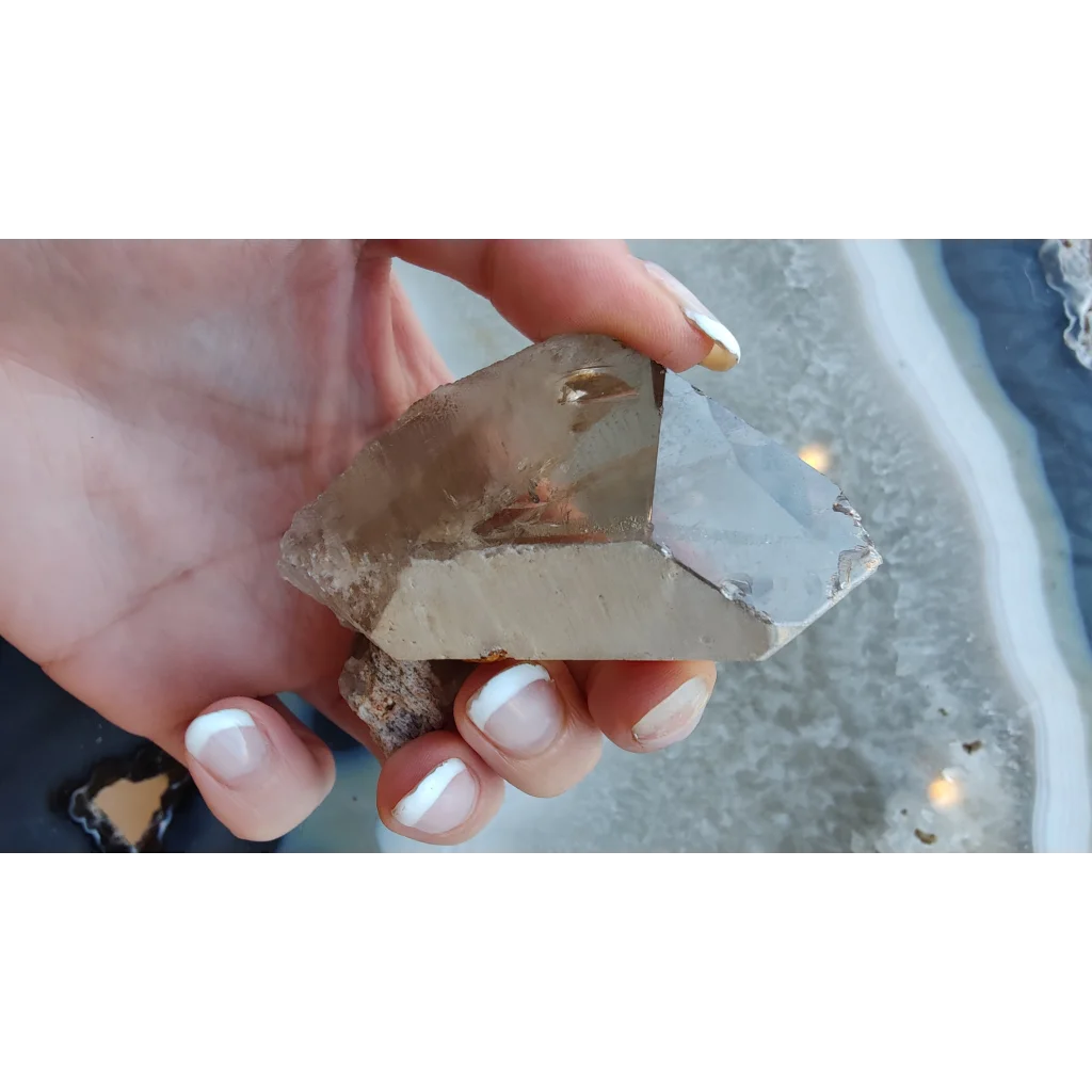 Hand holding lodalite included smoky quartz crystal from Brazil