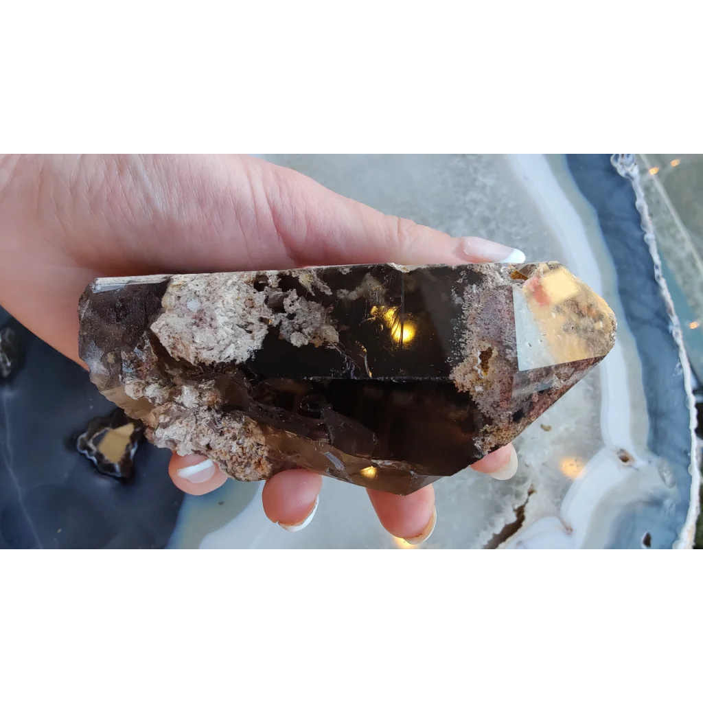 Hand holding lodalite included smoky quartz crystal from Brazil