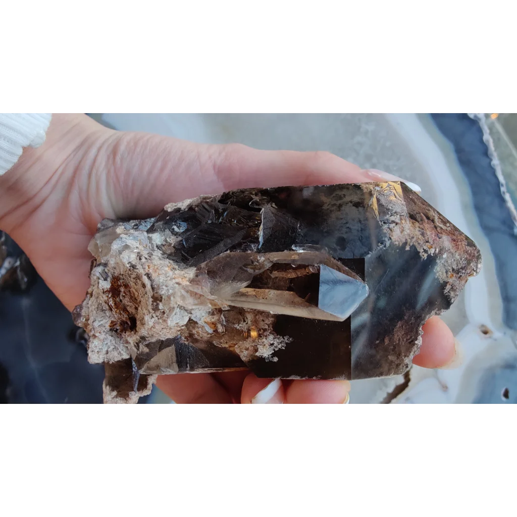 Hand holding lodalite included smoky quartz with phantoms from Brazil