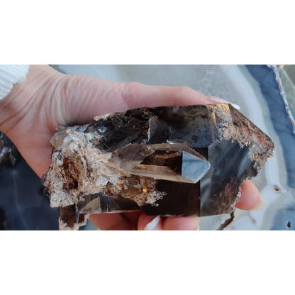 Hand holding lodalite included smoky quartz with phantoms from Brazil