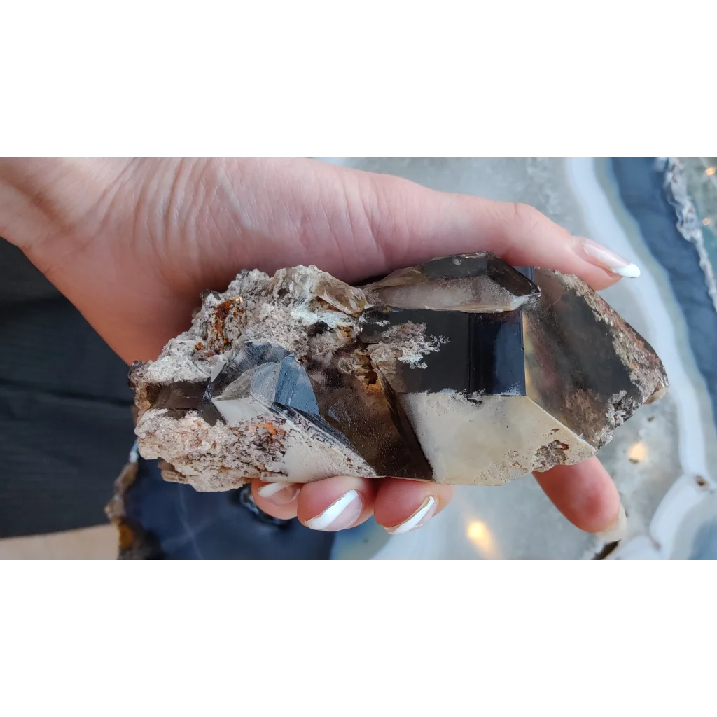 Hand holding lodalite included smoky quartz cluster from Brazil