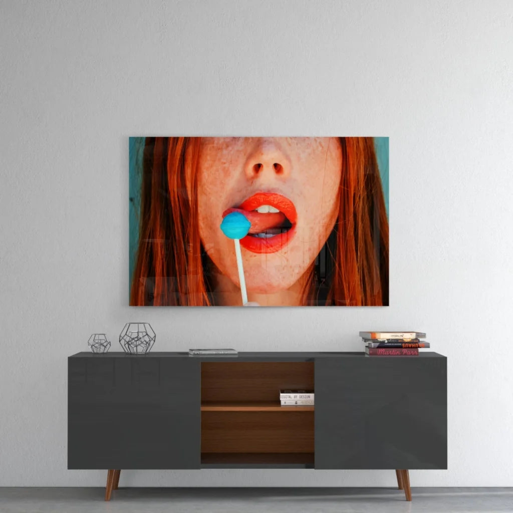Vibrant pop art redhead glass wall art with blue lollipop close-up