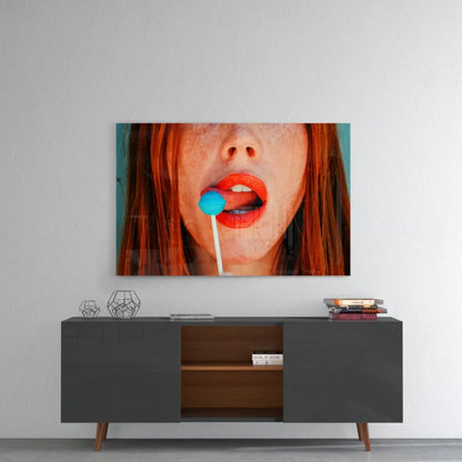 Vibrant pop art redhead glass wall art with blue lollipop close-up