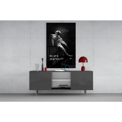 Black-and-white astronaut wall art poster on gray table, we are starstuff print