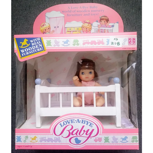 Vintage 1987 Love-a-bye Baby Doll in pink outfit with brown hair and wooden crib