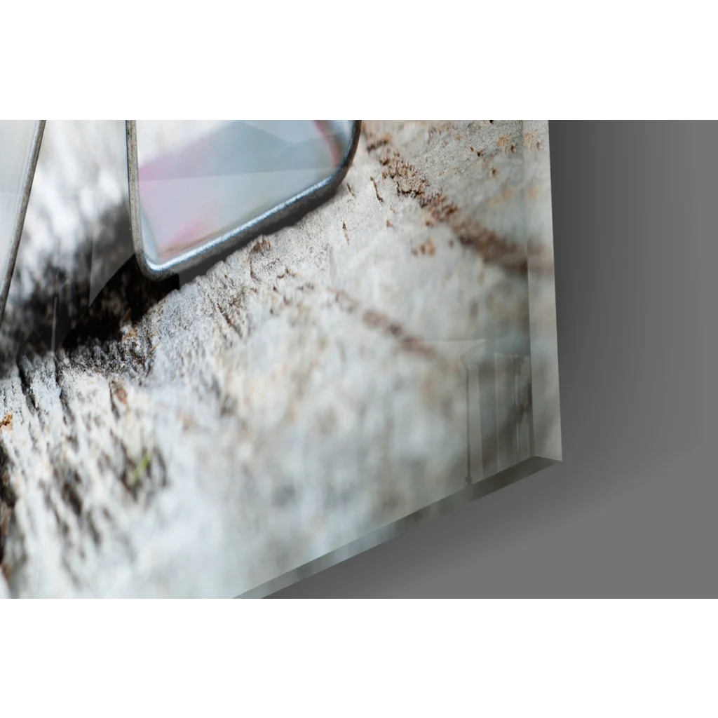 Sleek silver smartphone on gray stone with Love Roses glass wall art