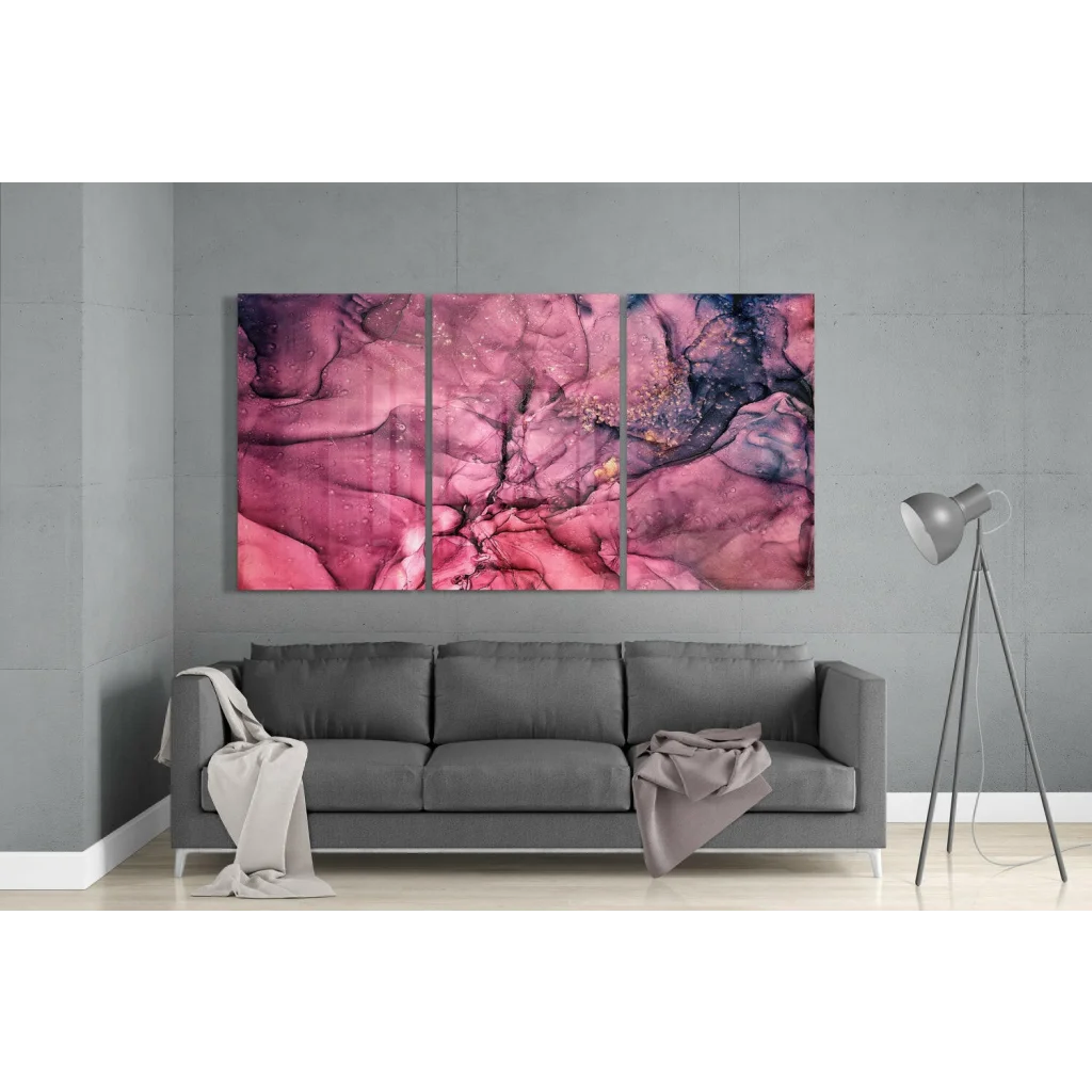 Vibrant pink purple swirl glass wall art triptych above gray sofa