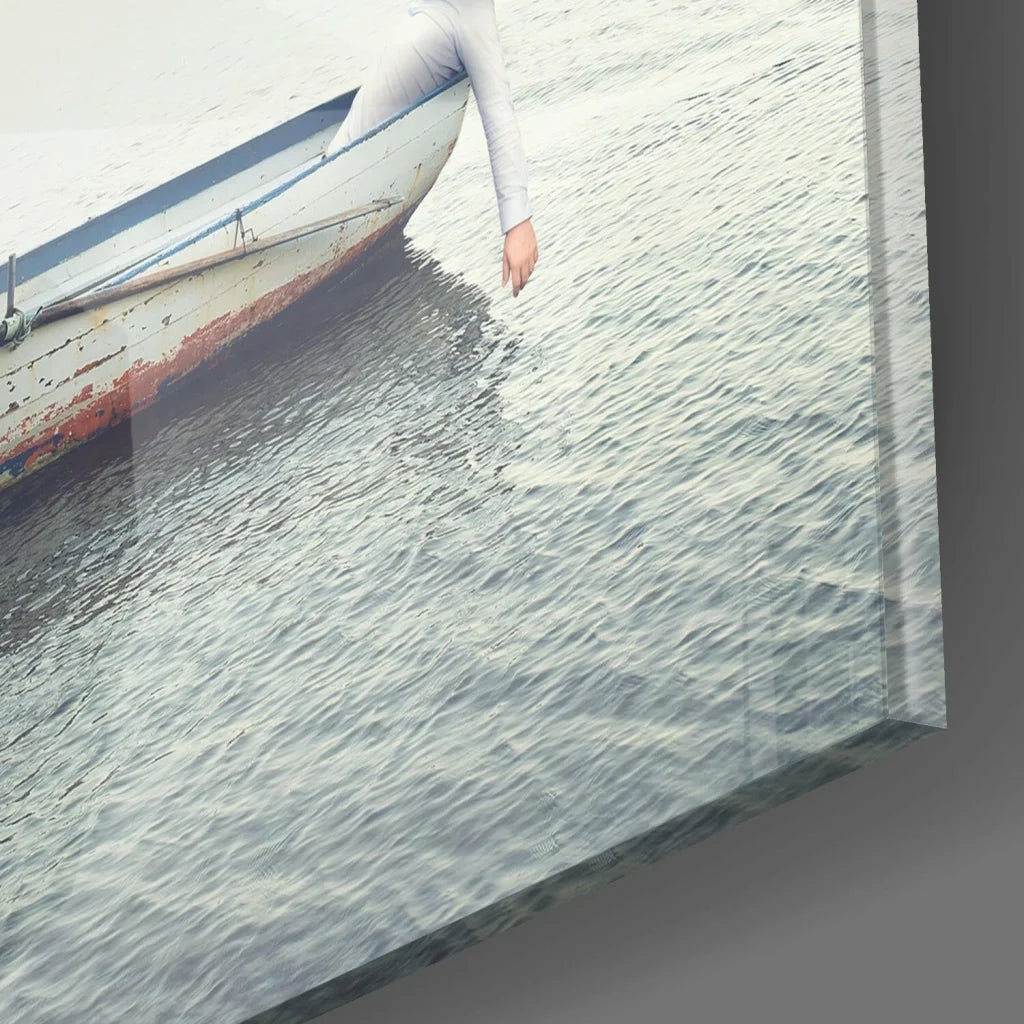Weathered white boat on glass wall art with arm reaching to water