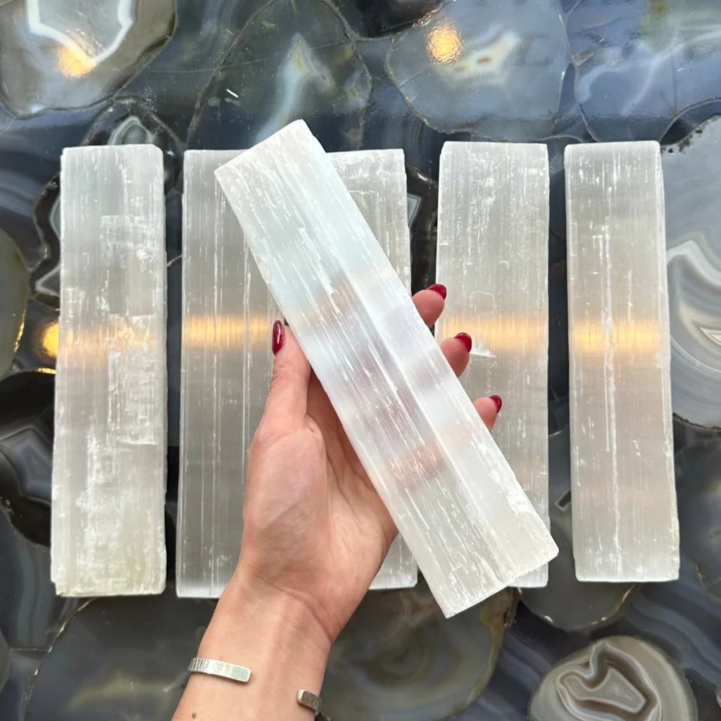 Hand holding massive 700g rough selenite bar from Morocco