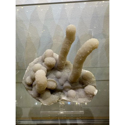 Medium chalcedony stalactite hand geode from India with pale crystalline stalks and nodules