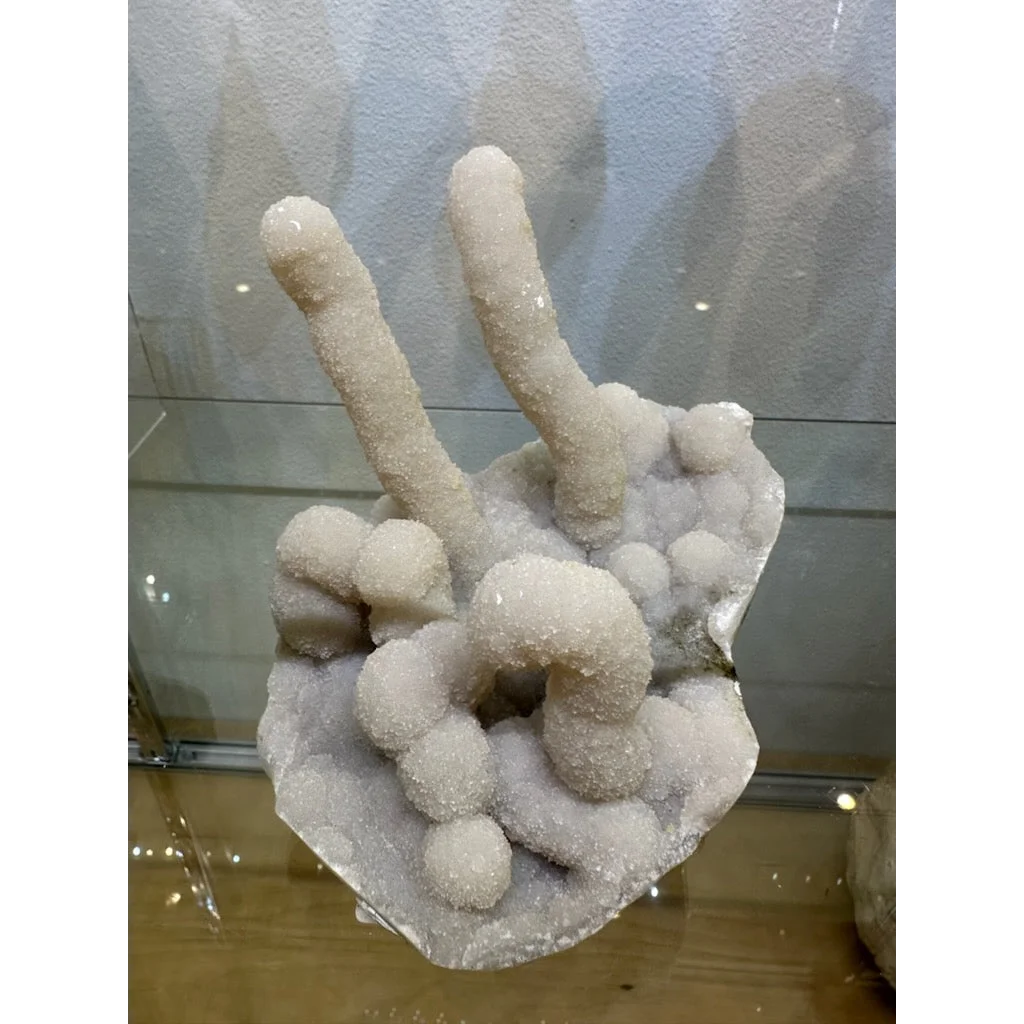 Medium chalcedony stalactite hand geode from India with white crystals