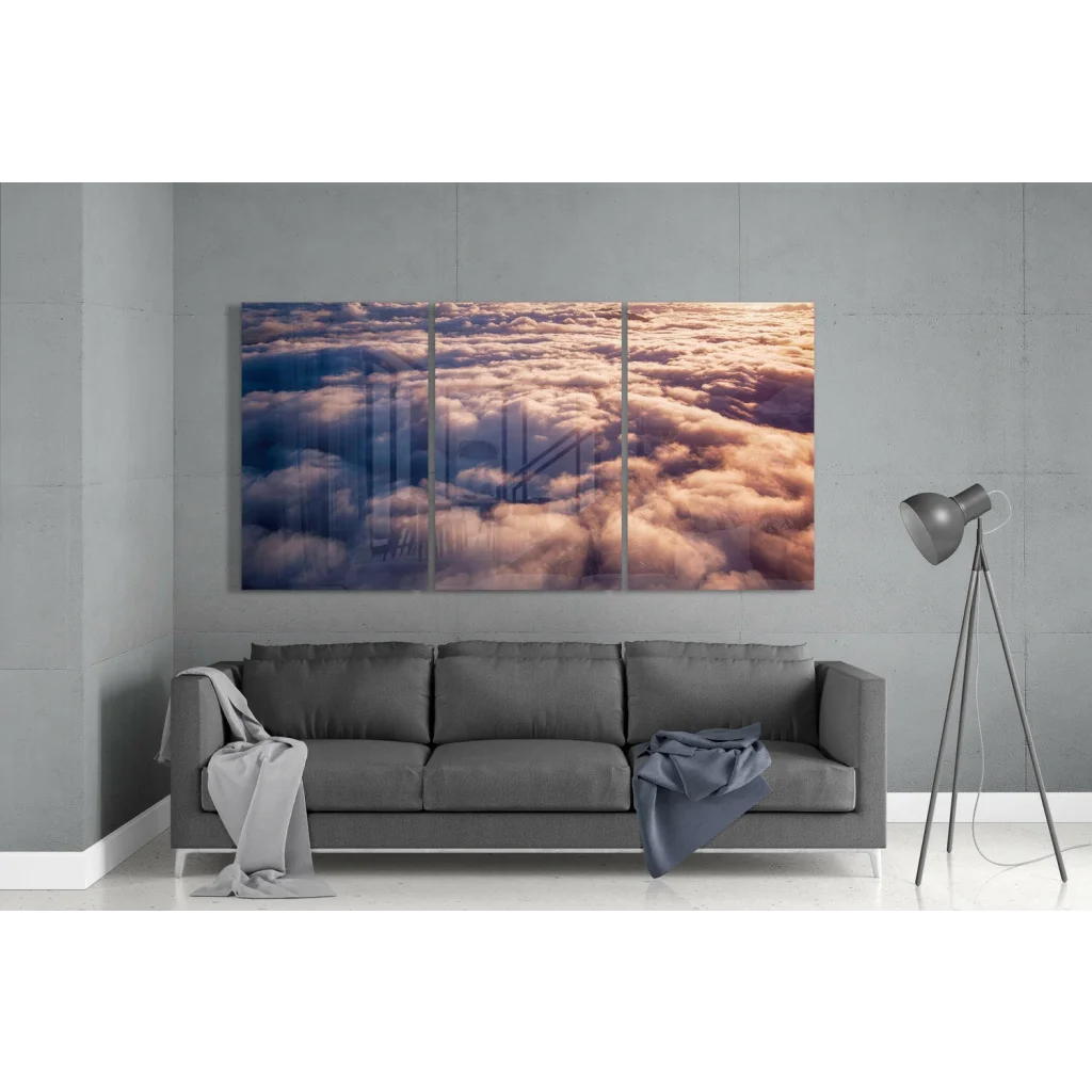 Golden hued cloudscape with bridge silhouette on stunning three panel glass wall art