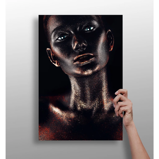 Hand holding black-and-gold glitter portrait of woman with metallic skin and glowing blue eyes canvas print