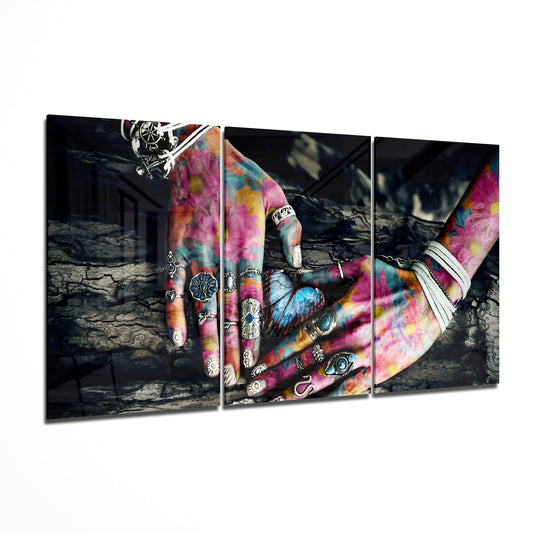 Three-panel glass wall art displaying tattooed hands with vibrant pink, yellow, and blue tie-dye patterns against a dark industrial background.