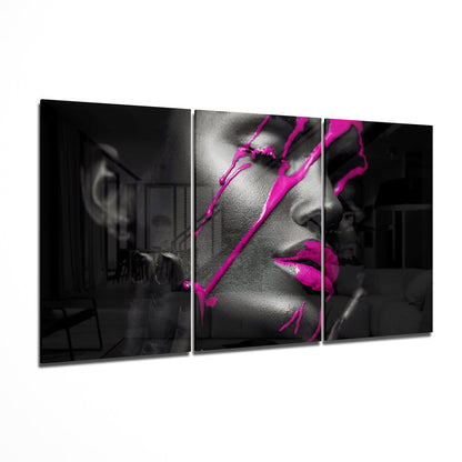 Three-panel glass wall art displaying black and white portrait with vibrant magenta ink splashes across face and neck.