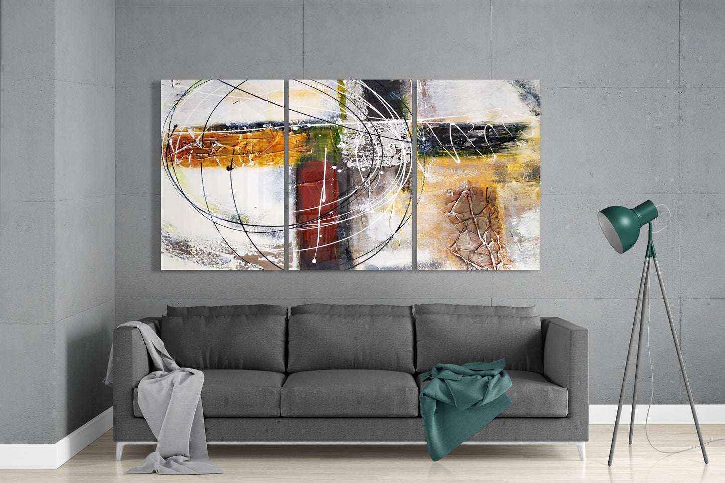 Three-panel abstract glass wall art with circular line designs, ochre, red, and cream tones, installed above gray sofa in modern living room.