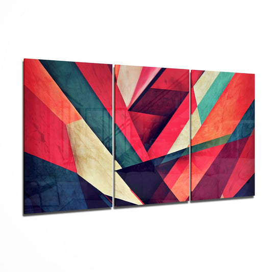 Three-panel glass wall art with overlapping diagonal stripes in red, navy, teal, orange, and cream, displayed at an angled perspective.