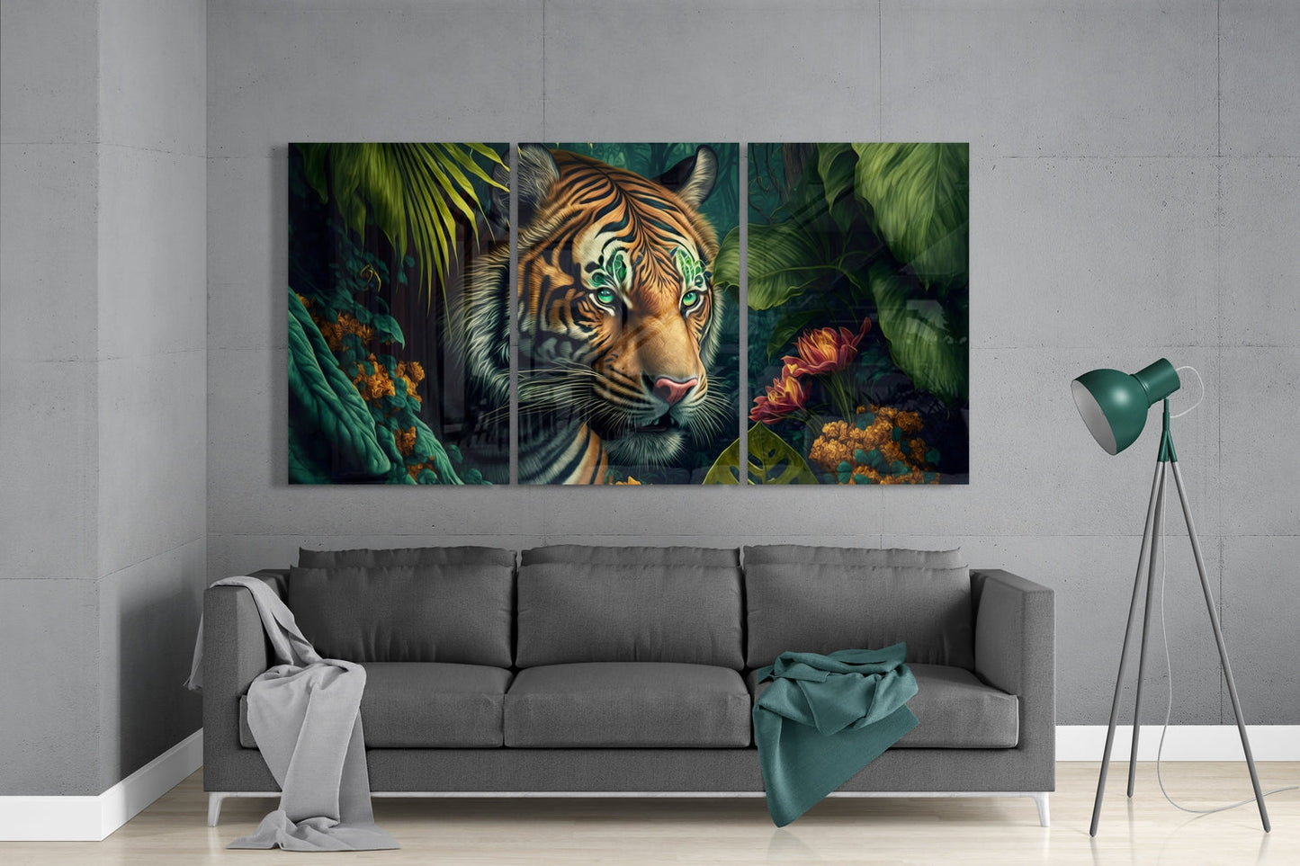 Three-panel glass wall art featuring a tiger with striking green eyes surrounded by lush green foliage and colorful flowers, displayed above a gray sofa.