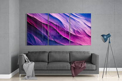 Three-panel purple and blue gradient glass wall art displayed above gray sofa in modern living room interior.