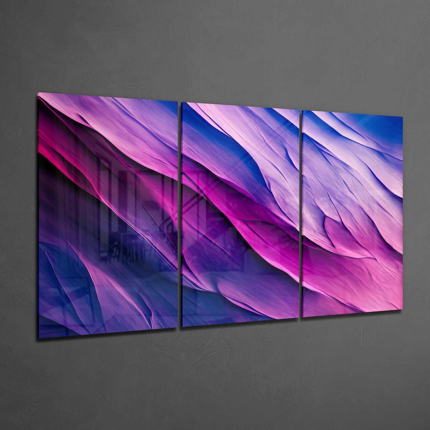 Three-panel purple glass wall art with flowing gradient waves transitioning from deep blue to magenta and light pink, displayed at an angle on gray wall.