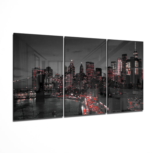 Three-panel black glass wall art displaying New York City skyline at night with red accent lighting and Brooklyn Bridge, angled product view.