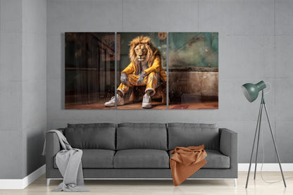 Multi-panel glass wall art displaying a lion wearing gold jacket and white sneakers seated indoors, hung above gray sofa in minimalist room.