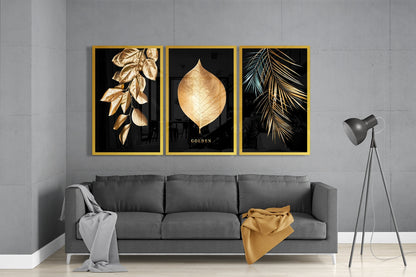 Three framed golden leaf prints on black backgrounds displayed above gray sofa in modern living room setting.