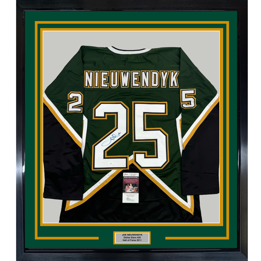 Framed dark green Dallas Stars hockey jersey number 25 with "NIEUWENDYK" nameplate, signed in blue ink, displayed flat against white matting with gold and yellow borders.