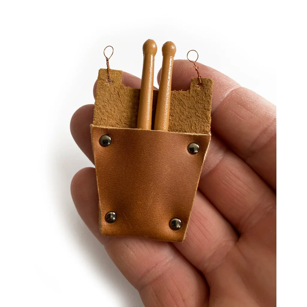 Tan mini leather drumstick bag with wooden sticks and metal loops