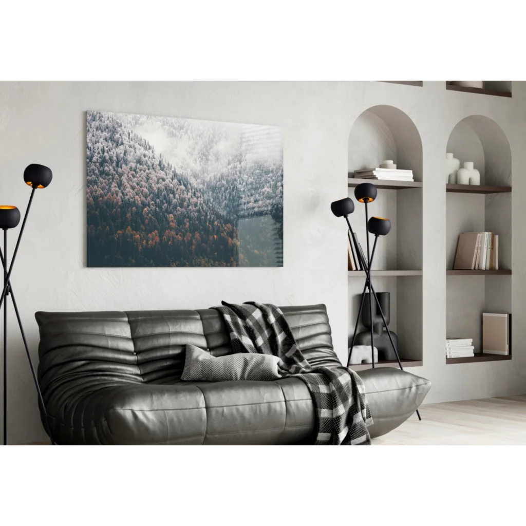 Black leather sofa with tufted cushions and plaid throw in Misty Mountain Forest glass wall art