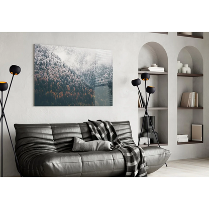 Black leather sofa with tufted cushions and plaid throw in Misty Mountain Forest glass wall art
