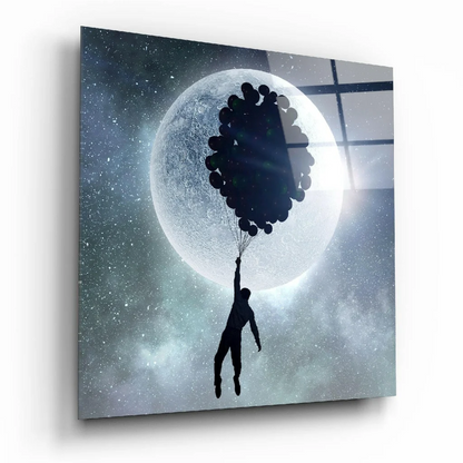 Black silhouette holding balloons against moon in glass wall art