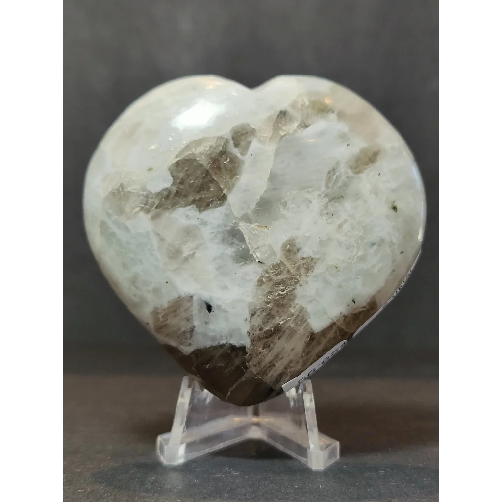 Moonstone polished heart sculpture with translucent white and grayish-brown crystalline pattern on acrylic stand