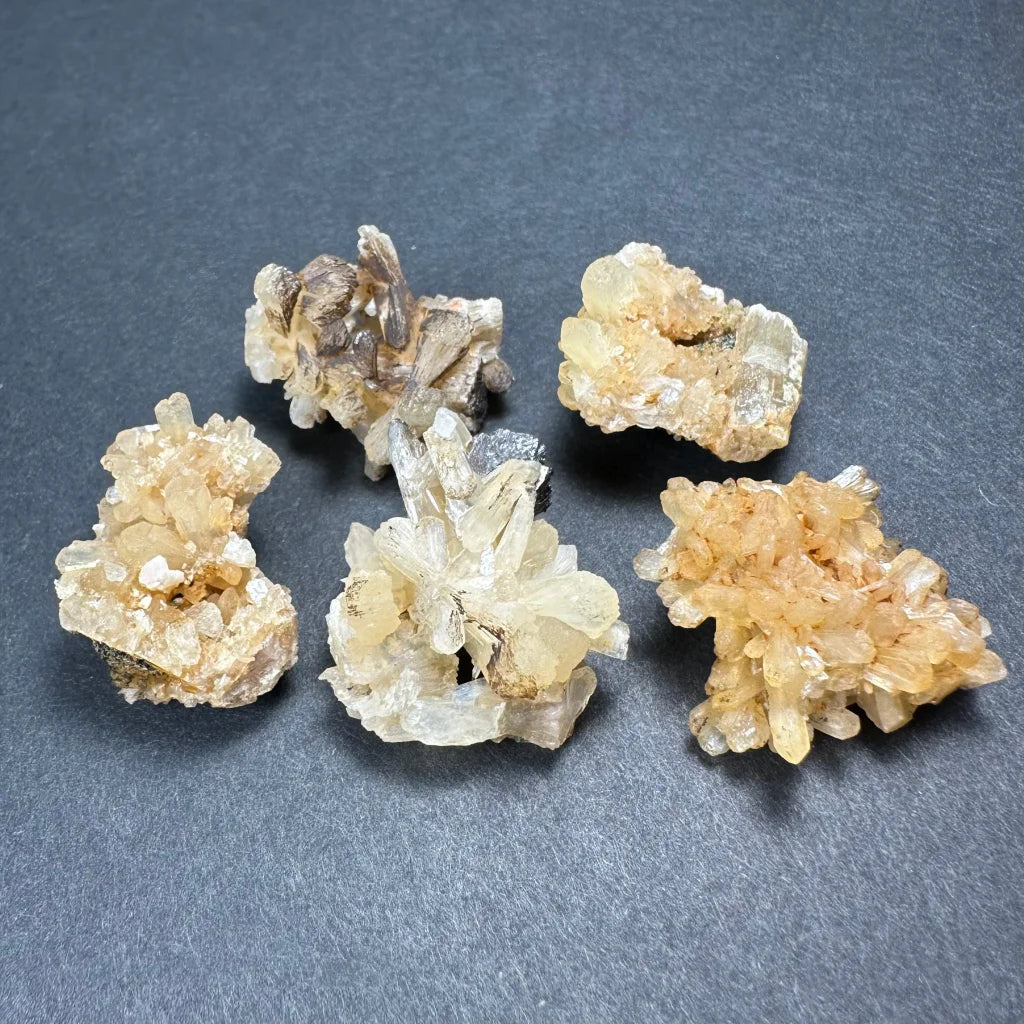 Five pale yellow crystalline thumbnail specimens in acrylic box