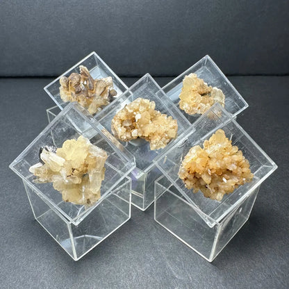 Moroccan thumbnail specimens in clear acrylic box with yellowish crystals