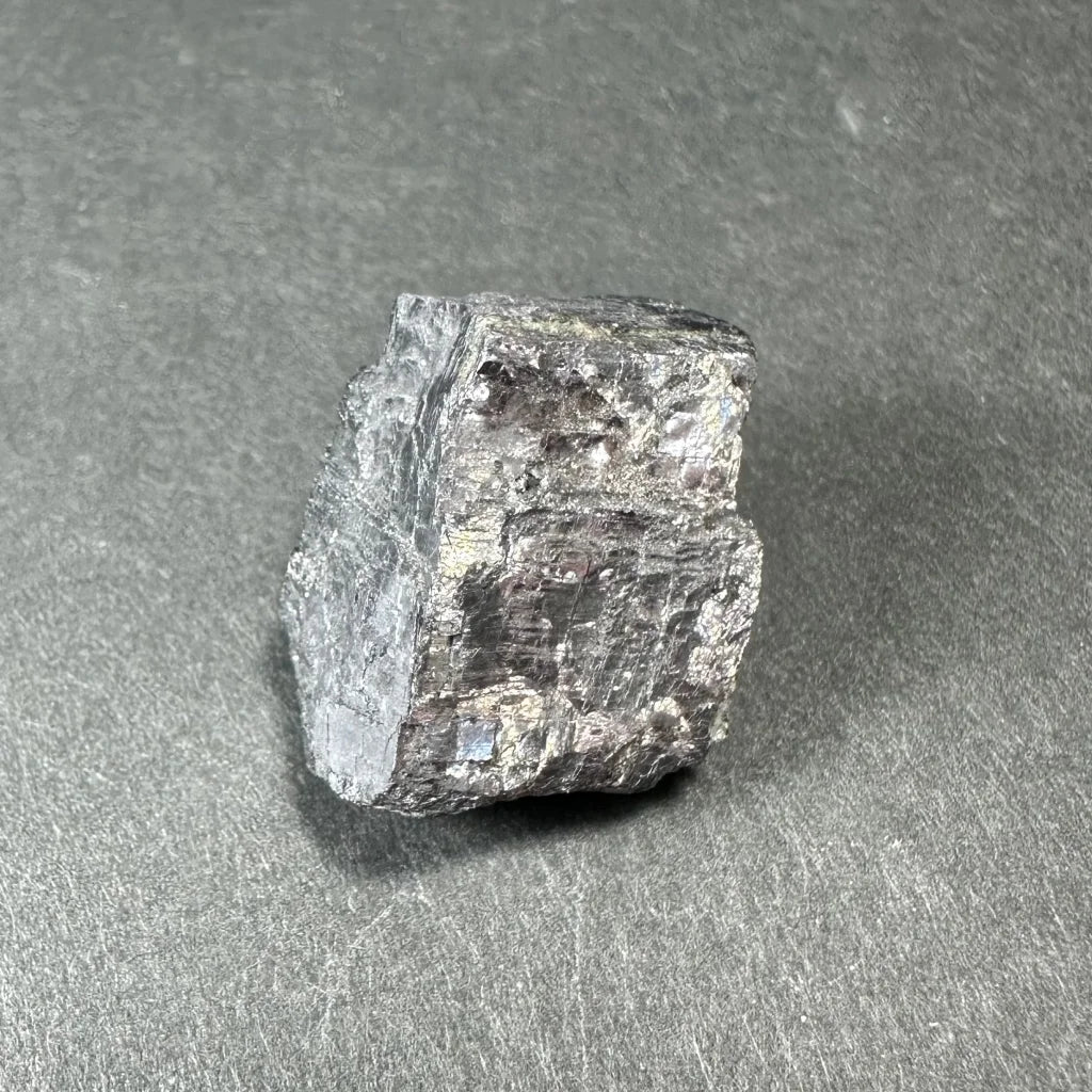 Rough silvery-gray Moroccan mineral thumbnail specimen in acrylic box