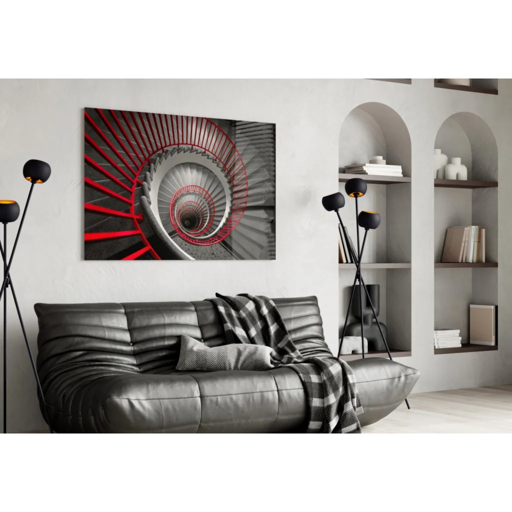 Modern black leather sofa with plaid throw under bold red spiral staircase wall art