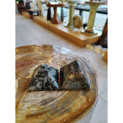 Moss agate pyramid India on rustic wood with black white swirls