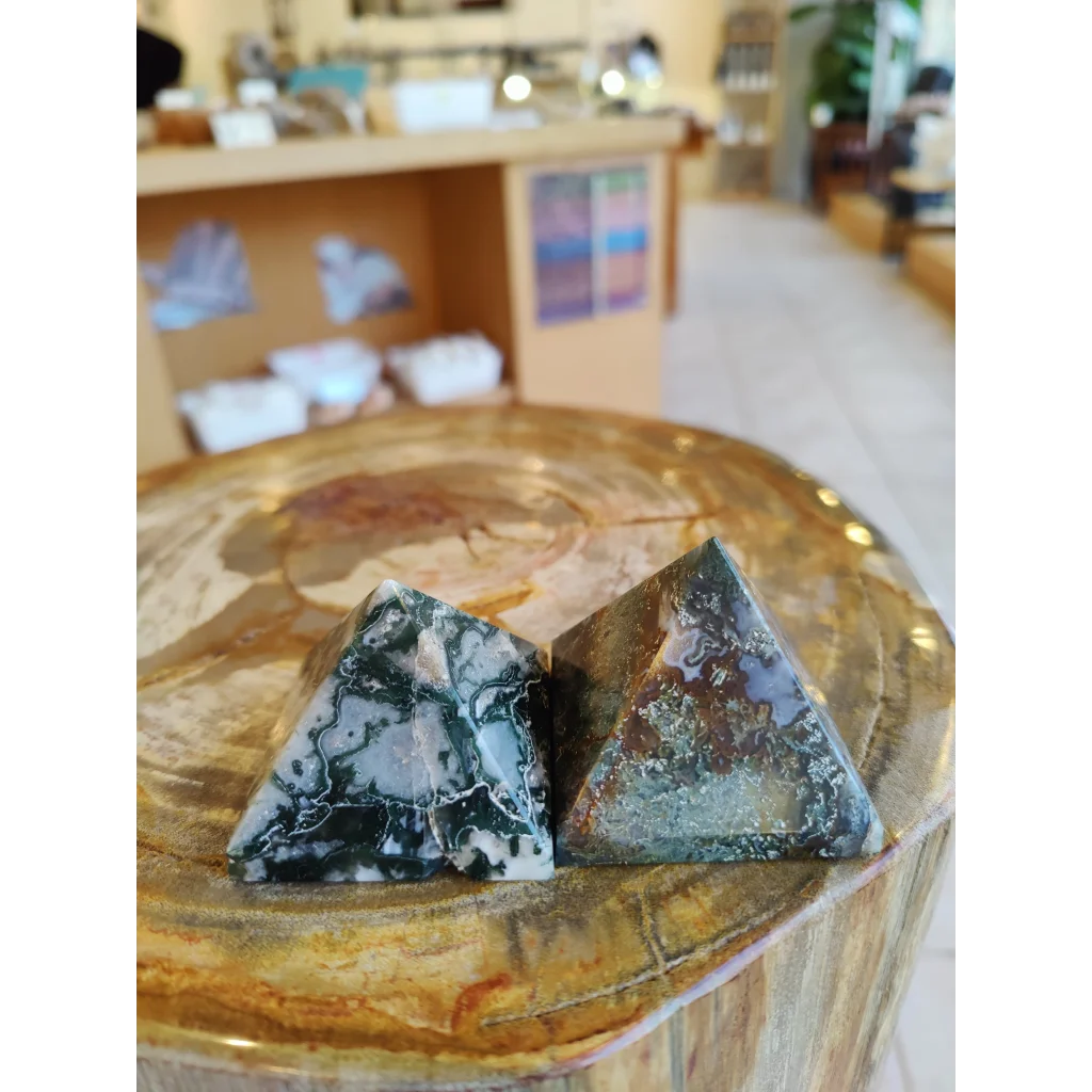 Two moss agate pyramids India with black white swirls on wood