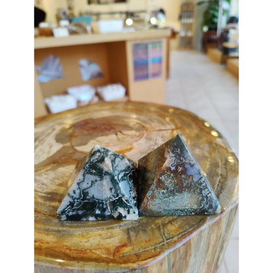 Two moss agate pyramids India with black white swirls on wood
