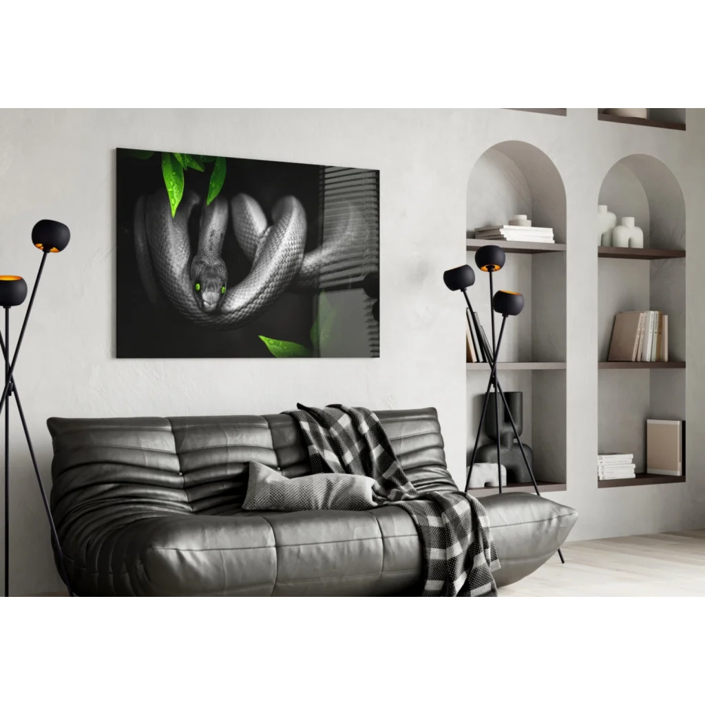 Mystical black snake glass wall art with emerald eyes on leather sofa