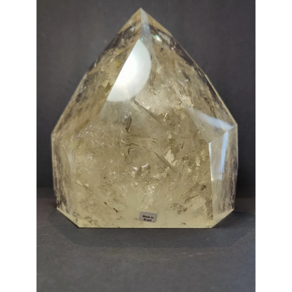 Natural citrine polished point weighing 4.1kg with a translucent pale yellow faceted pyramid shape and internal inclusions