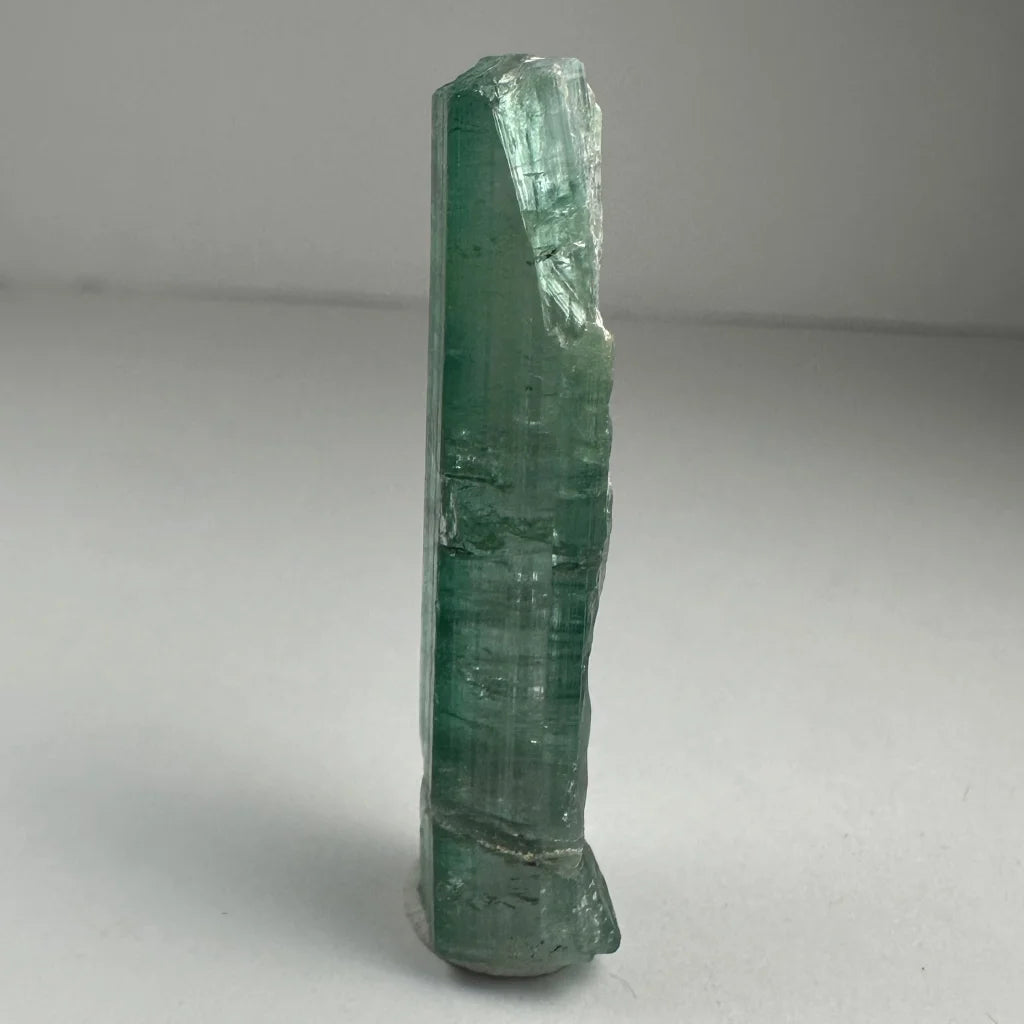 Translucent green indicolite tourmaline crystal with faceted shape