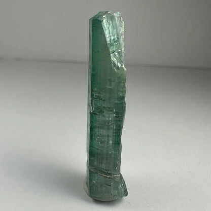 Translucent green indicolite tourmaline crystal with faceted shape