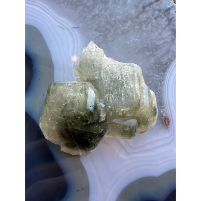 Natural green fluorapatite cluster on swirling agate slab