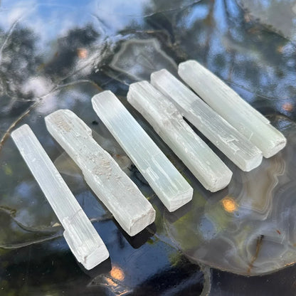 Six translucent selenite sticks with natural striations and rough edges