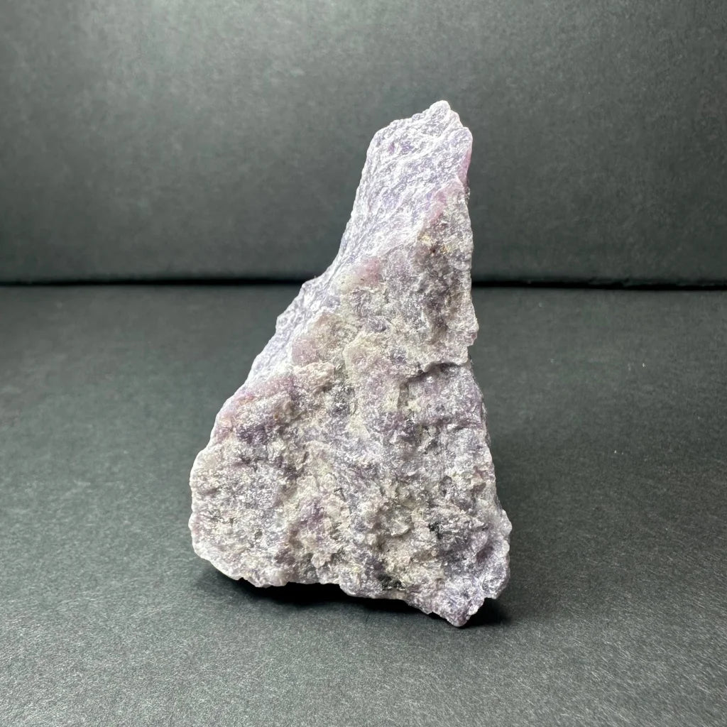 Rough purple lepidolite geode specimen with textured gray surface